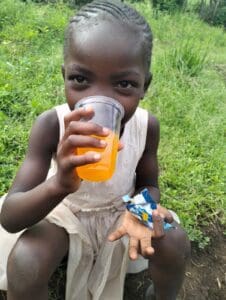 A Kenyan child enjoying a nourishing drink at an RDM outreach