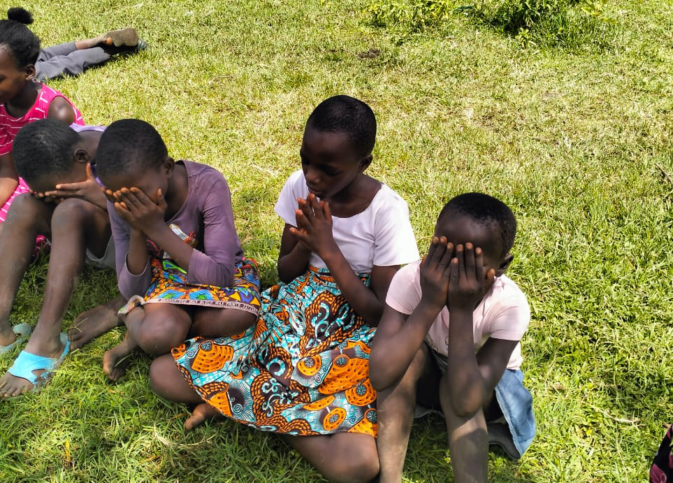 Children discovering the vision at an RDM outreach on the grass