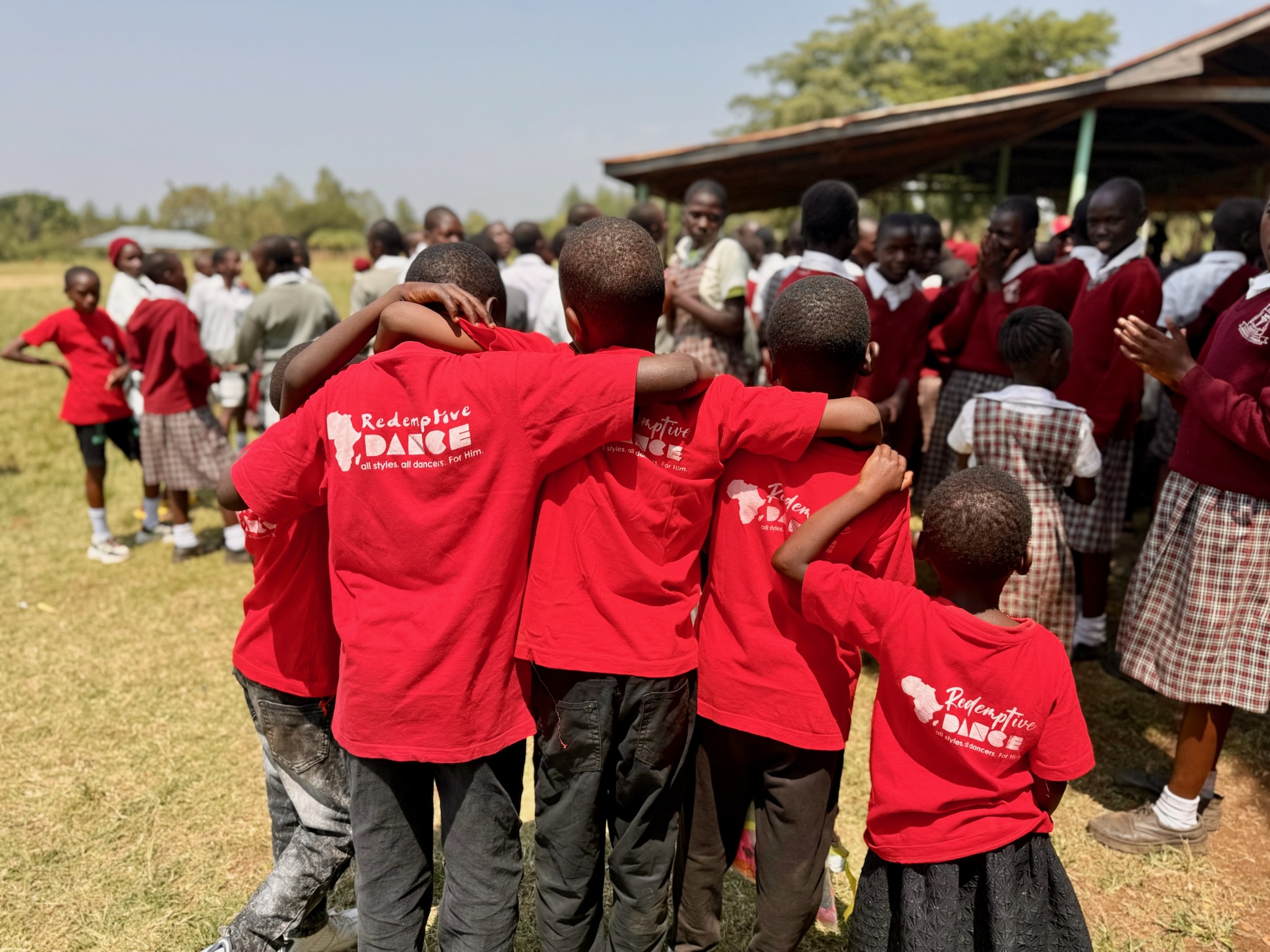 Children in Redemptive Dance Ministries shirts embracing after worship