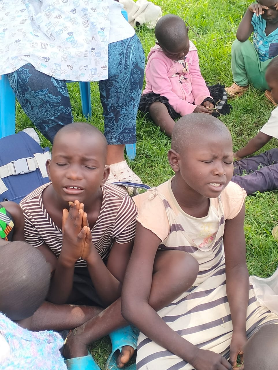 Children in prayer at RDM.life's Kenyan chapter, reflecting on the spiritual aspect of dance and community engagement.