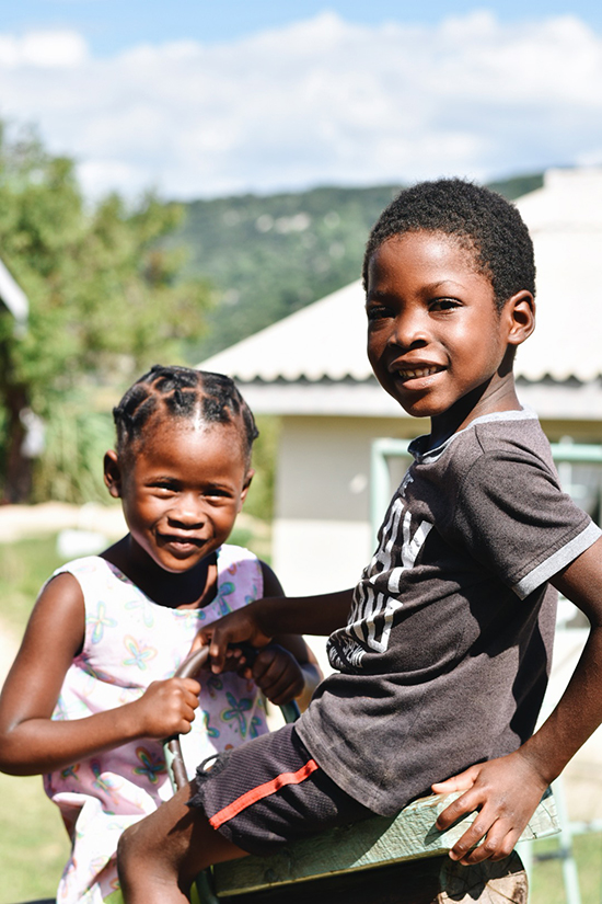 Two young children from RDM.life's Zimbabwe chapter share a cheerful moment, embodying the joy of community connection.