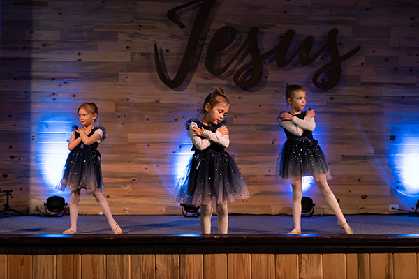 Young dancers performing at RDM's Castle Rock spring event, with 'Jesus' sign in the backdrop, celebrating faith through dance.