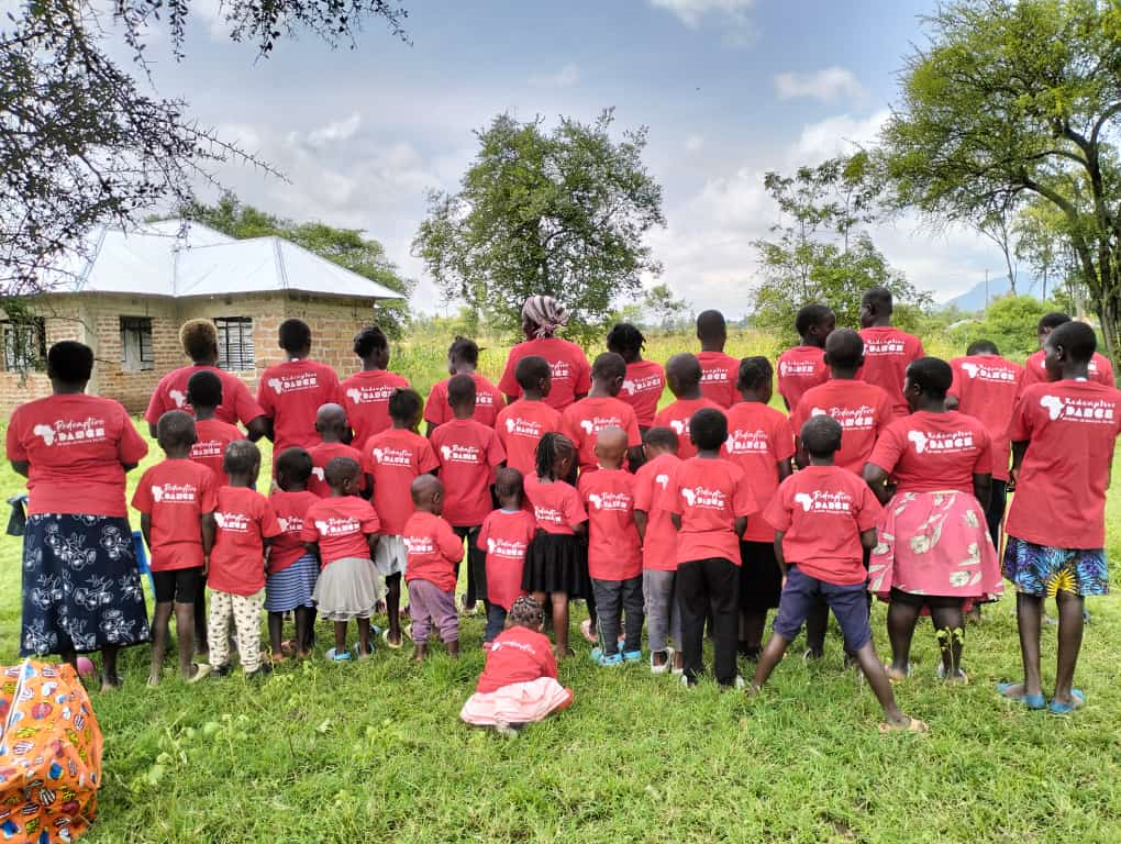 Students of EmpowerDance Collective's Kenya chapter in red t-shirts standing together in a natural setting, representing RDM's mission to glorify God through dance.